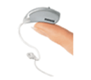 A small hearing aid, about an inch long, resting on the tip of a persons finger.