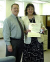 thumbnail link to larger image, two people standing at a desk holding a certificate